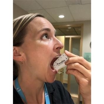 Hilary Cochrane, demonstrating how to measure the mouth opening for a patient.